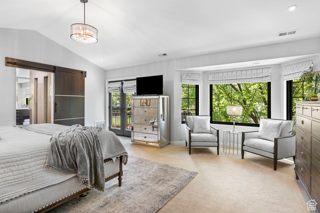 Bedroom with vaulted ceiling, a barn door, and carpet