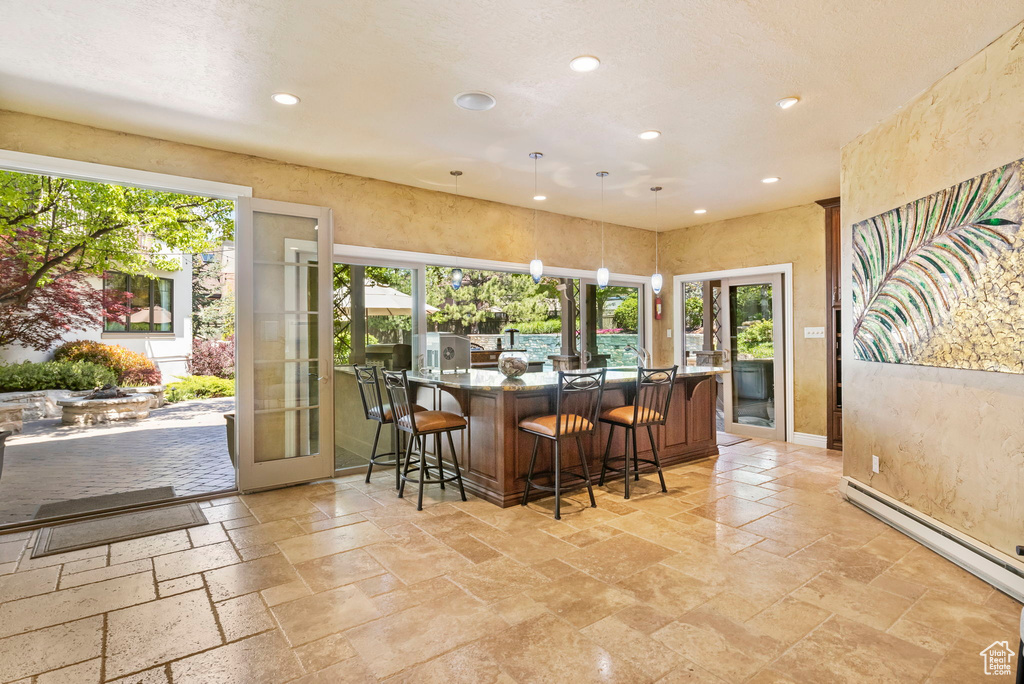 Indoor wet bar featuring french doors, healthy amount of natural light, recessed lighting, and stone tile floors