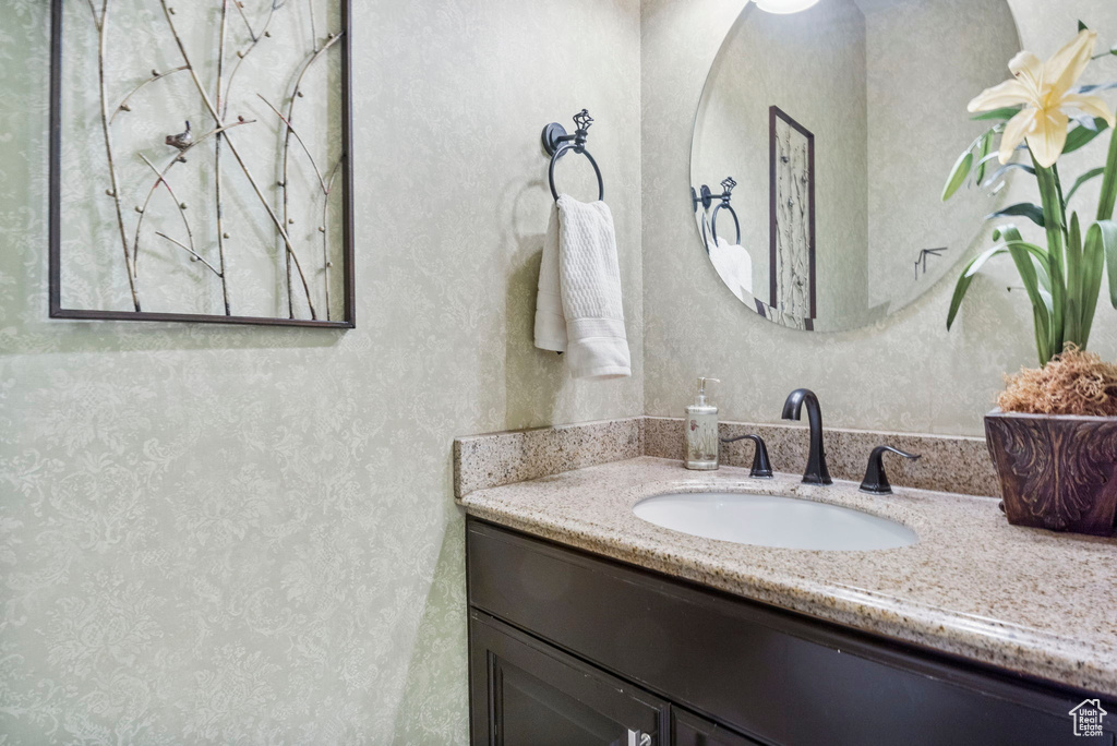Bathroom with vanity and wallpapered walls