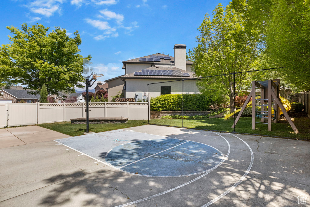 View of sport court with a playground and basketball hoop