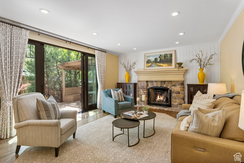 Living area featuring ornamental molding, wood finished floors, a fireplace, and recessed lighting