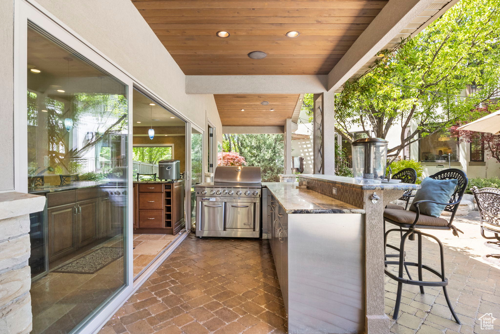 View of patio featuring exterior kitchen and a grill