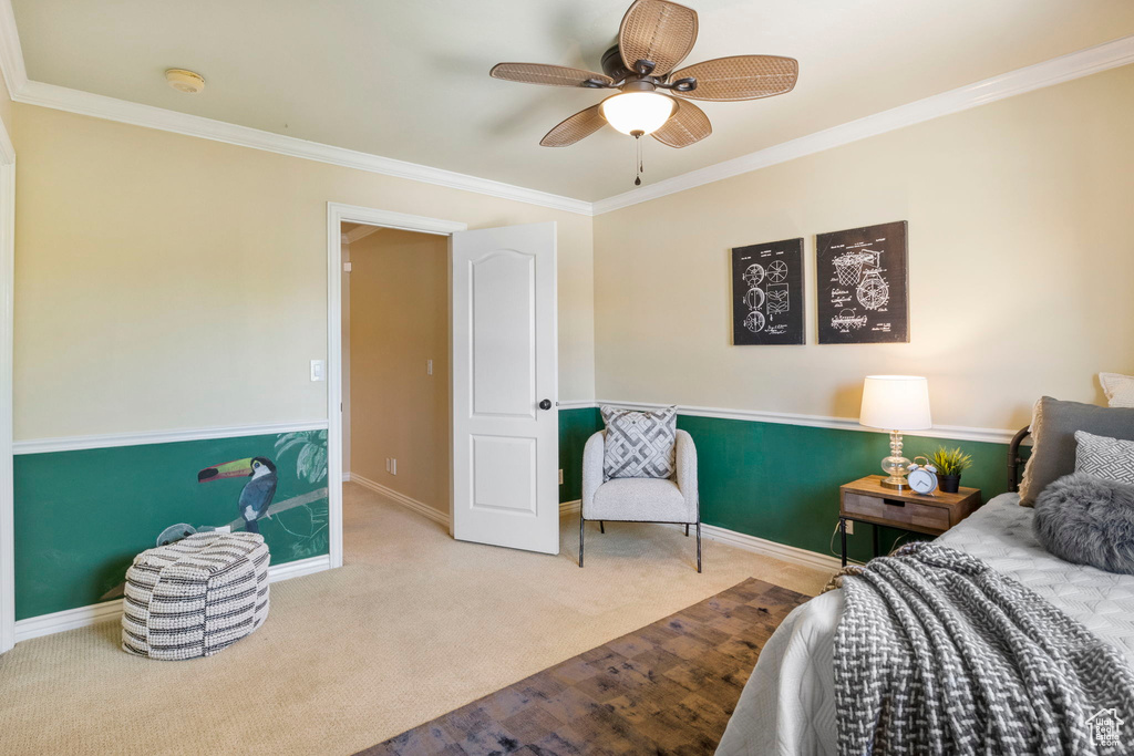 Carpeted bedroom with crown molding, baseboards, and ceiling fan