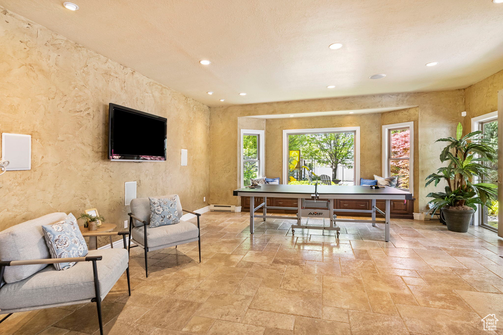 Office space with stone tile floors, recessed lighting, a baseboard radiator, and baseboards