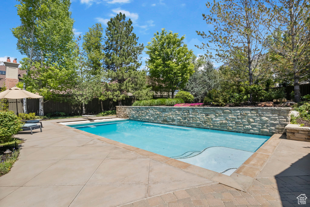 View of swimming pool with fence and a patio area