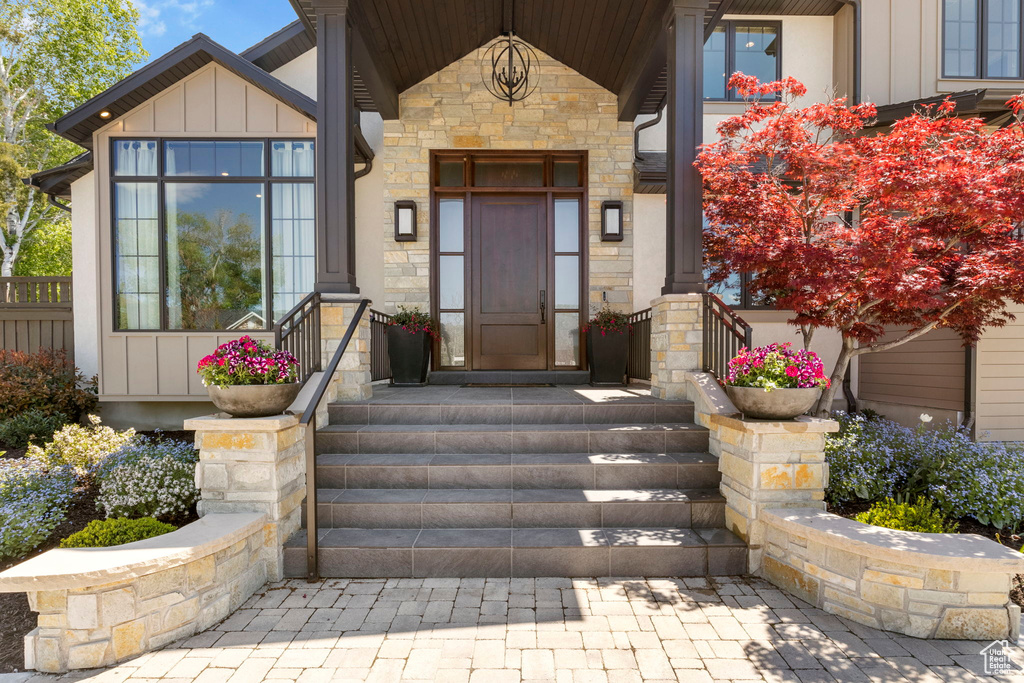 Doorway to property with board and batten siding and stone siding