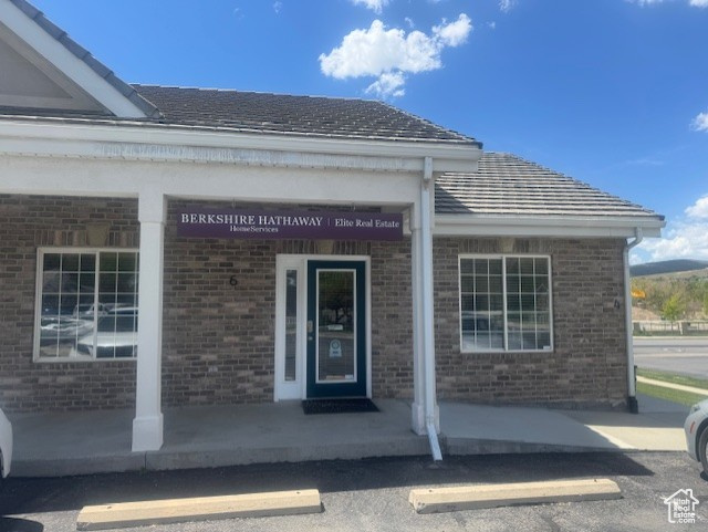 Entrance to property featuring brick siding and uncovered parking