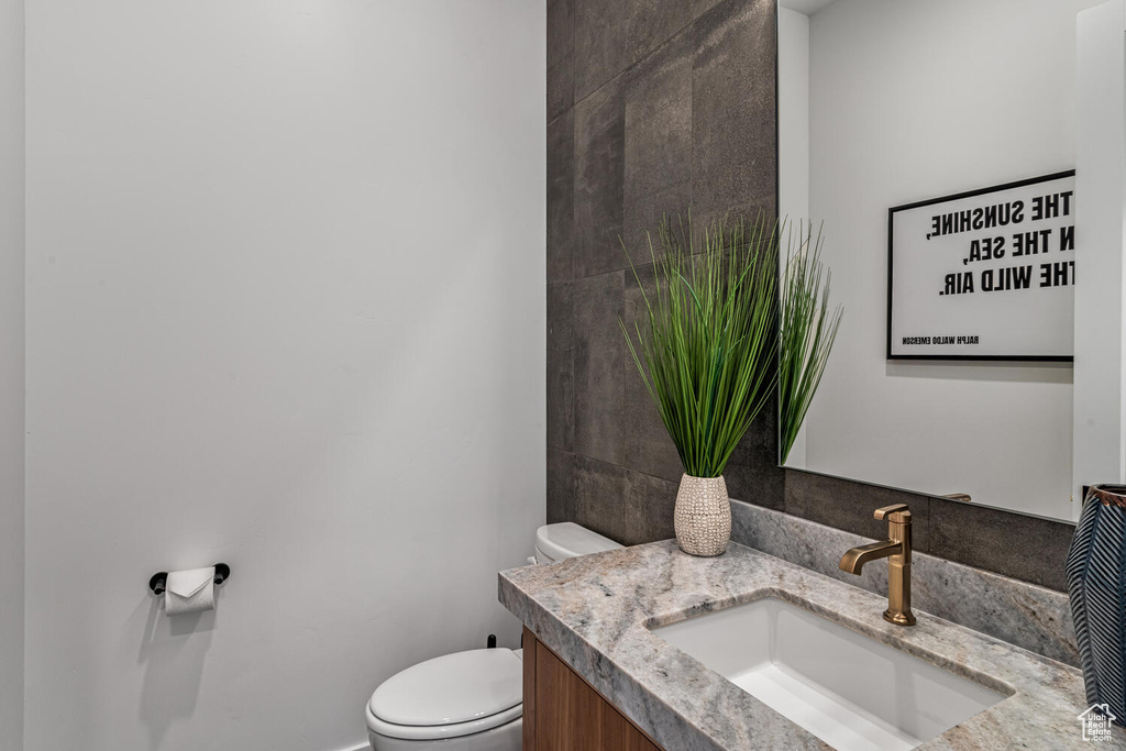Bathroom featuring toilet, vanity, and baseboards