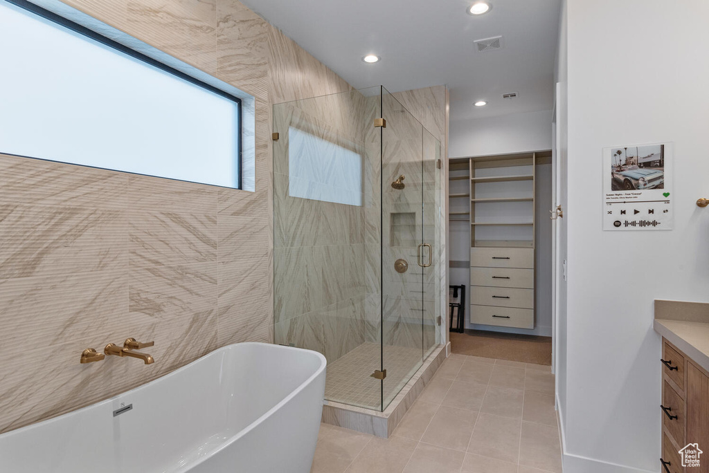 Full bathroom with a stall shower, a freestanding tub, vanity, tile patterned floors, and recessed lighting