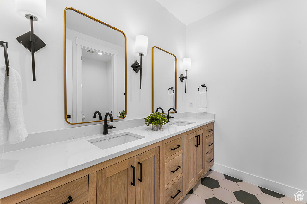 Bathroom featuring double vanity and baseboards