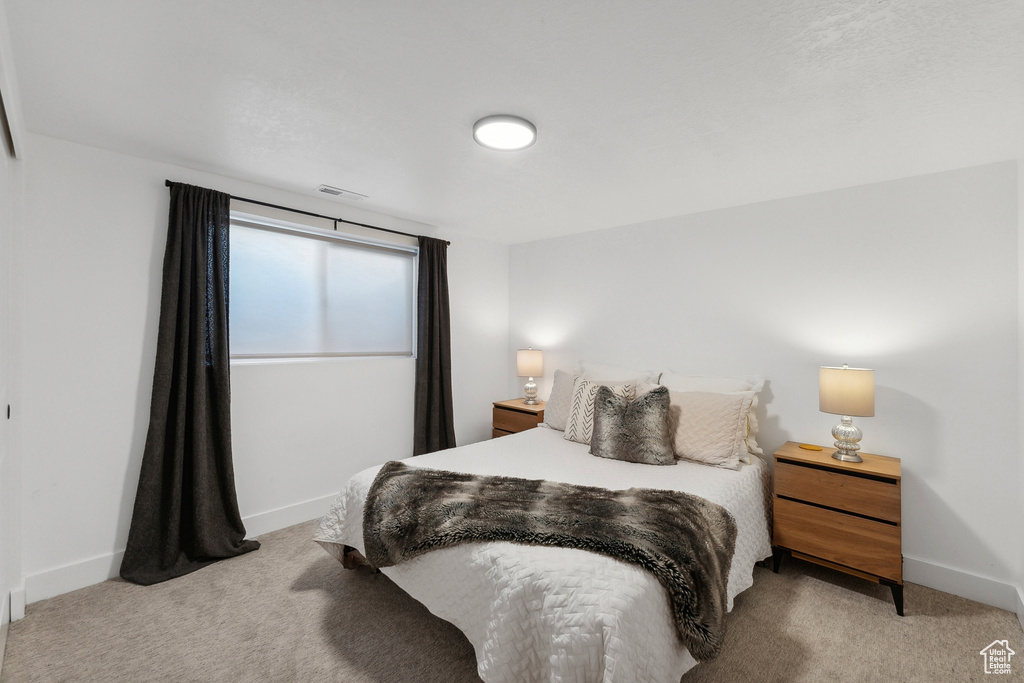 Bedroom featuring light carpet and baseboards
