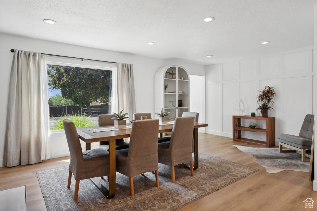 Dining area with light wood-style floors and recessed lighting