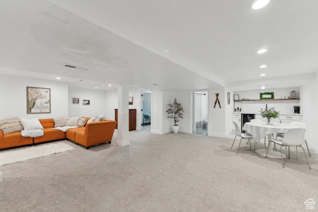 Living room with wet bar, recessed lighting, and baseboards