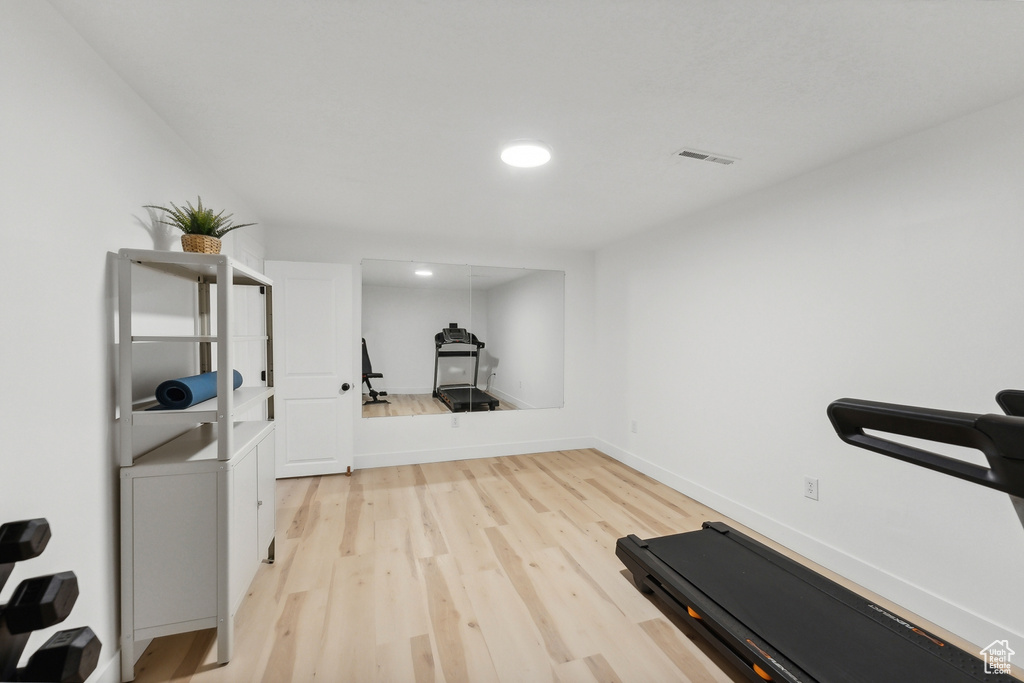 Exercise room with light wood-style floors, recessed lighting, and baseboards
