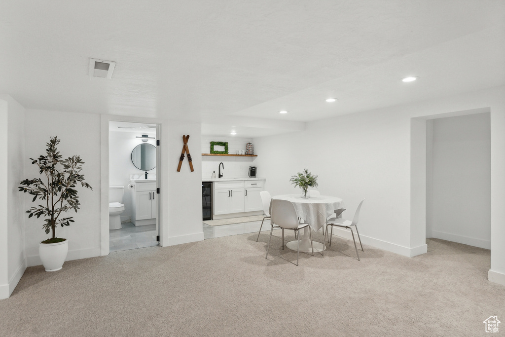 Dining space with wet bar, light carpet, recessed lighting, and baseboards