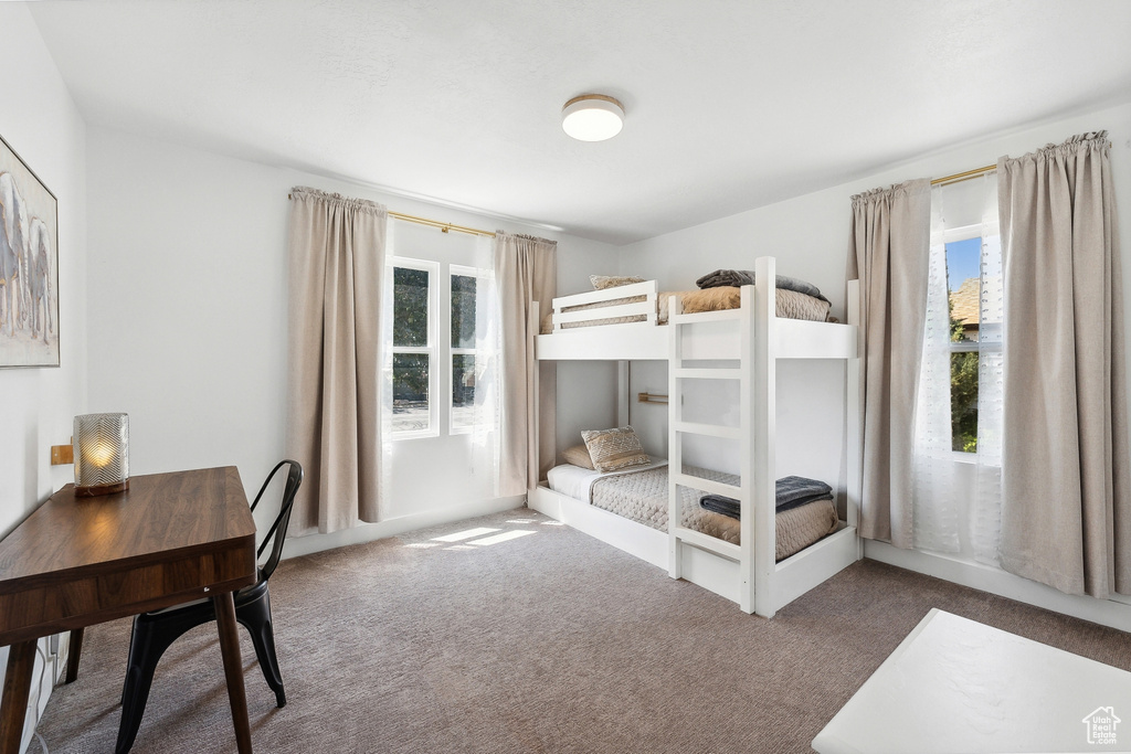 Carpeted bedroom featuring an office area