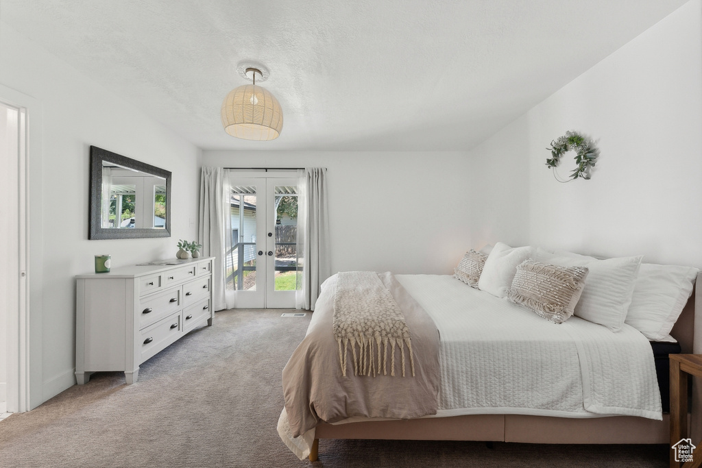 Bedroom featuring french doors, light colored carpet, and access to outside