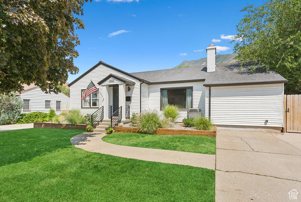 View of front of property with driveway, an attached garage, and a chimney