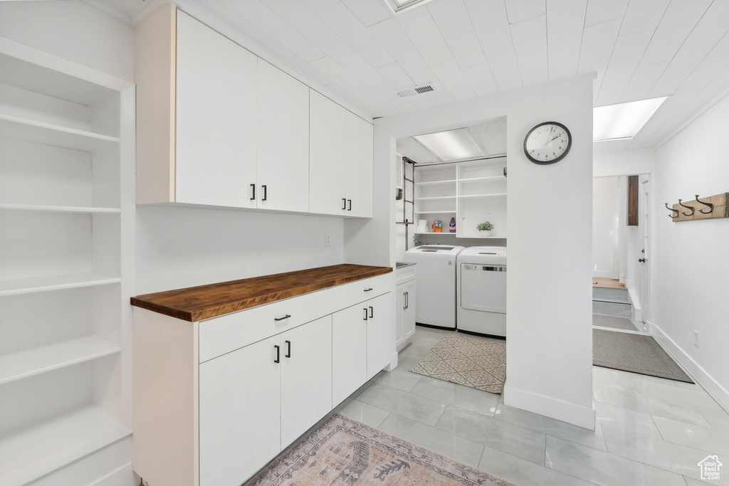 Kitchen featuring washing machine and dryer, wood counters, white cabinets, and built in features