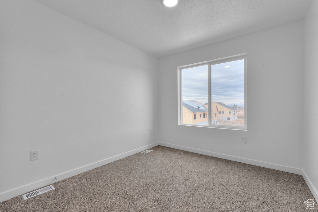 Unfurnished room featuring carpet floors, baseboards, and vaulted ceiling