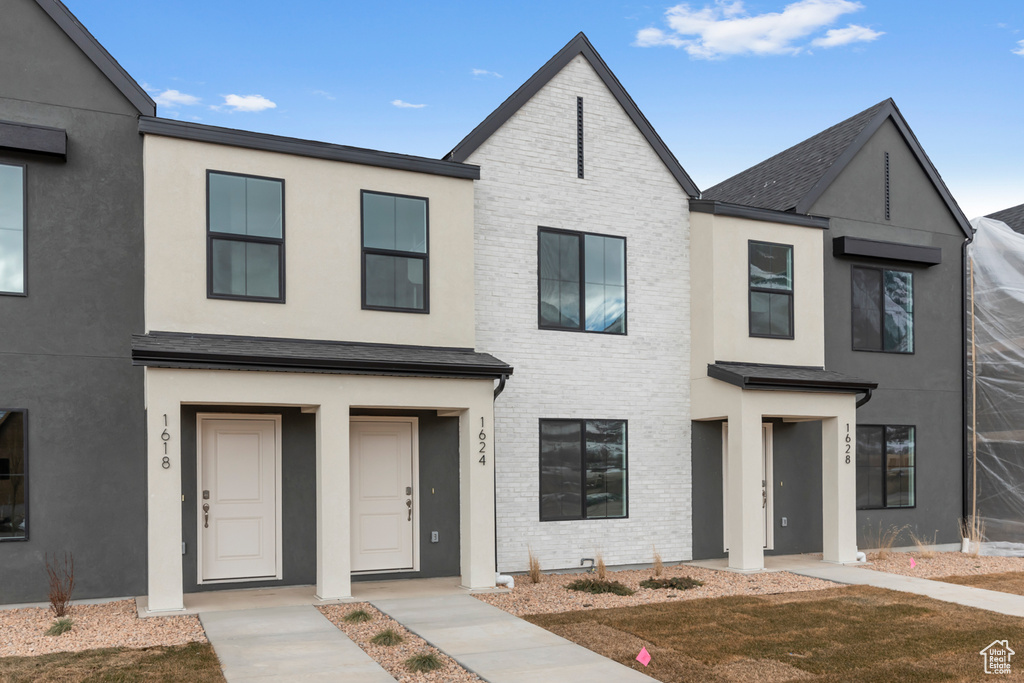 Townhome / multi-family property featuring stucco siding and brick siding