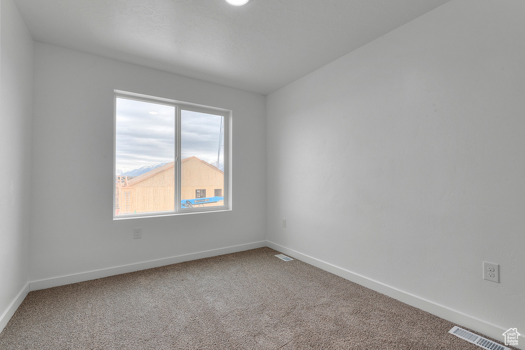 Spare room with carpet and baseboards