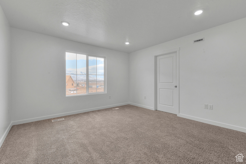 Carpeted spare room with recessed lighting and baseboards