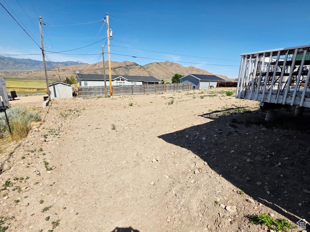 View of yard featuring a mountain view and a storage unit