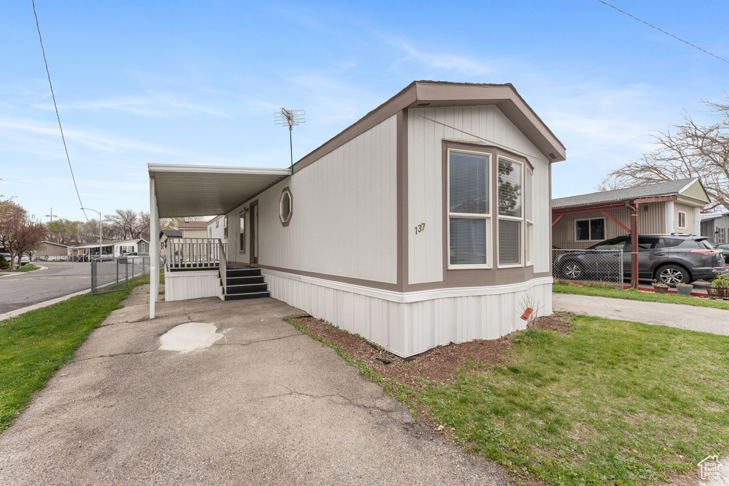 View of front of house with a carport and concrete driveway