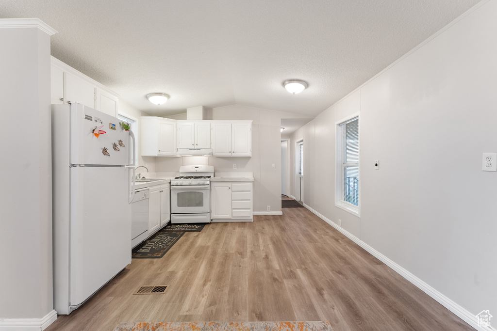 Kitchen with visible vents, light countertops, white appliances, under cabinet range hood, and white cabinetry