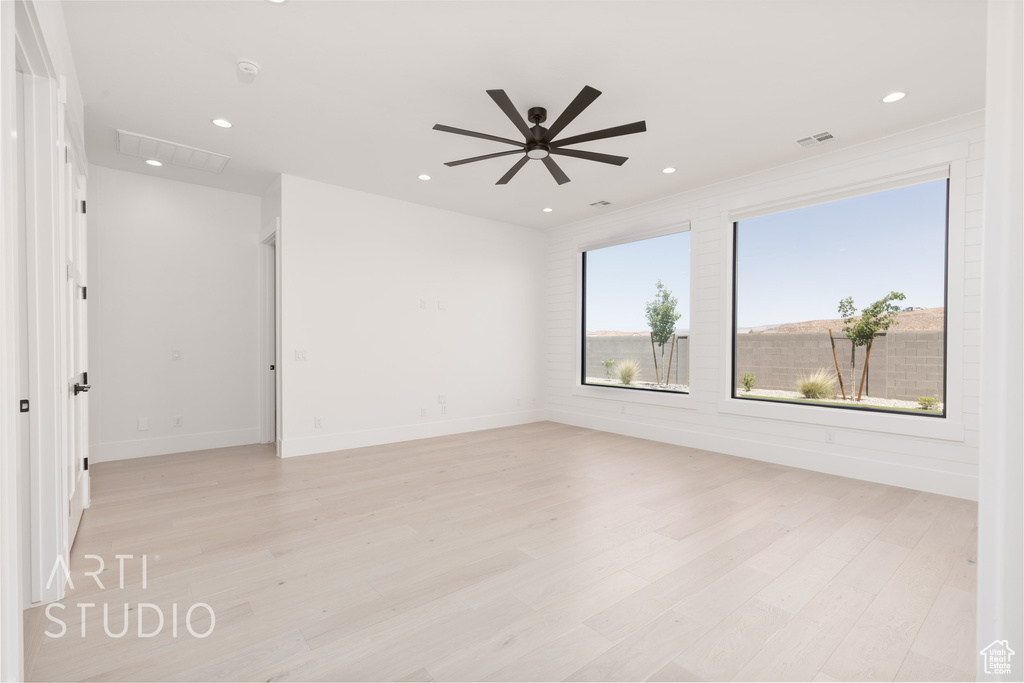 Empty room featuring light wood finished floors, recessed lighting, a ceiling fan, and baseboards