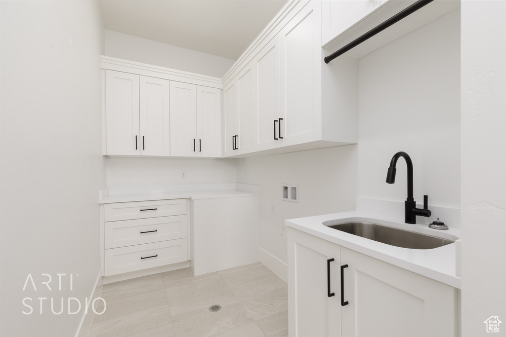 Laundry area featuring washer hookup, cabinet space, and baseboards
