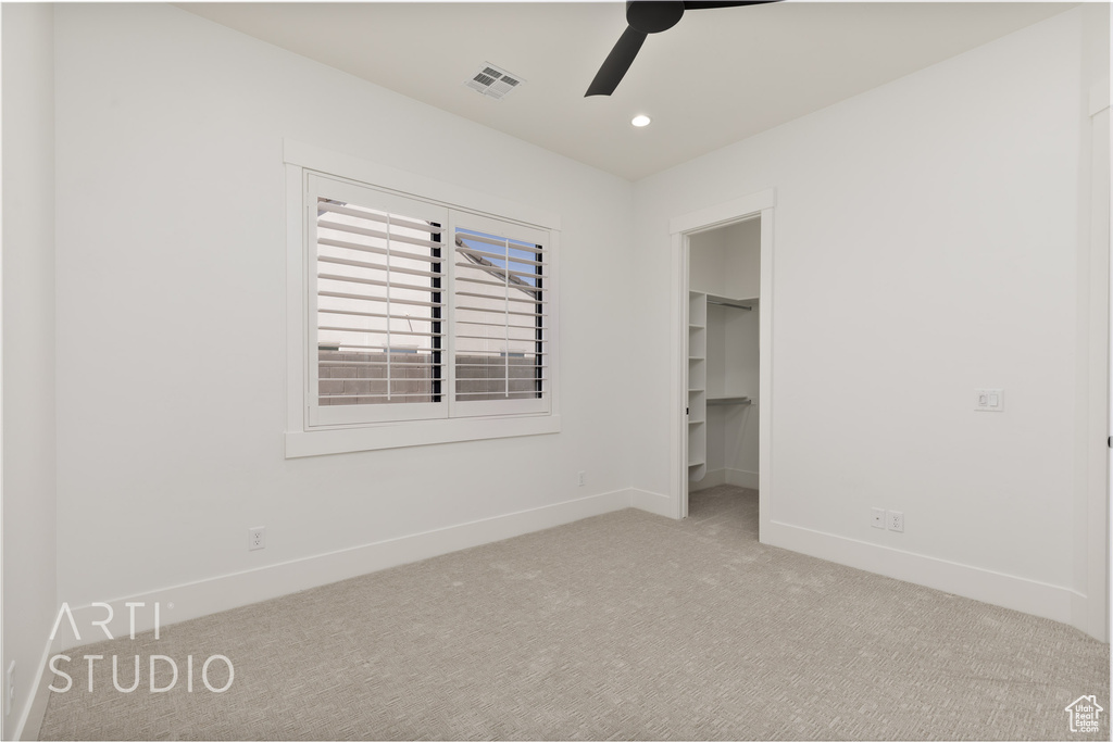 Unfurnished bedroom with baseboards, carpet flooring, a walk in closet, recessed lighting, and a closet