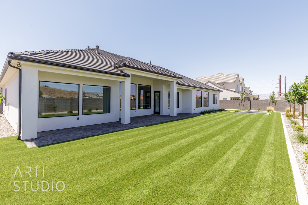 Back of property featuring stucco siding and a tiled roof