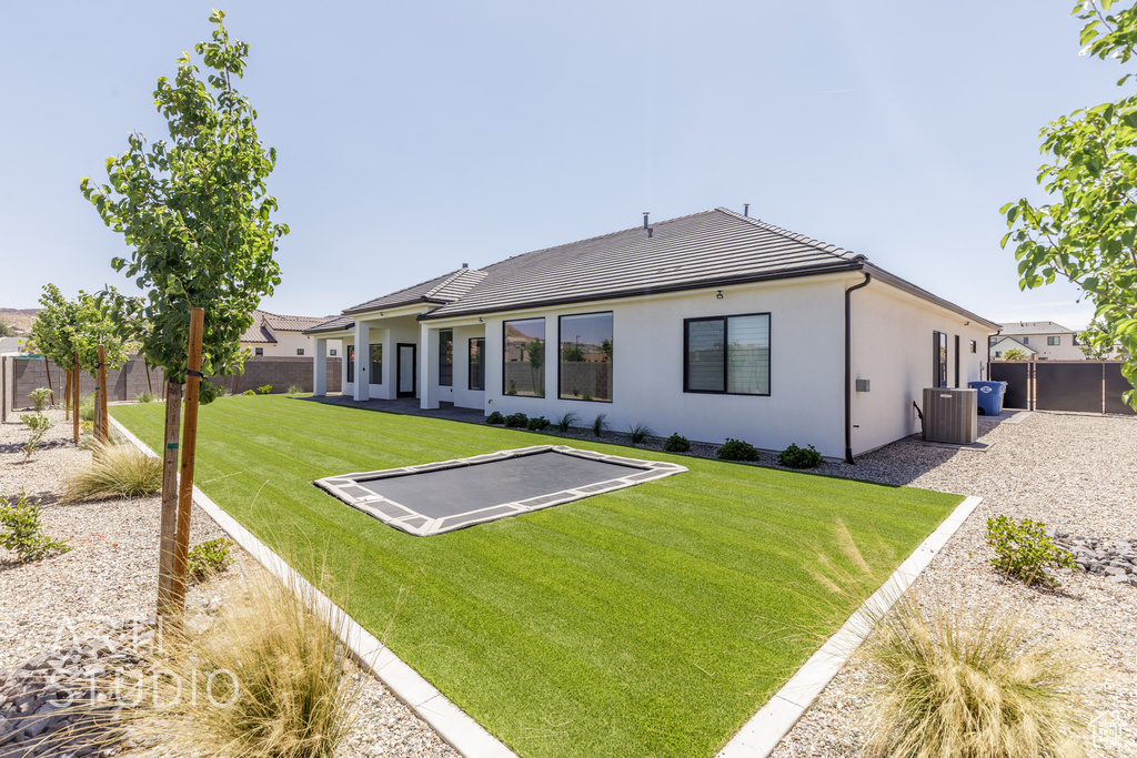 Back of house featuring central AC, a tile roof, stucco siding, and a patio