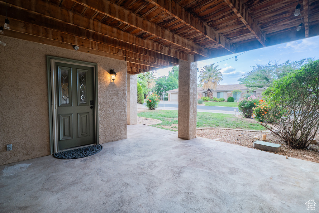 View of exterior entry with stucco siding and a patio