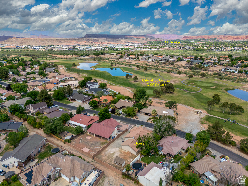 Aerial perspective of suburban area with a water and mountain view and a local golf course