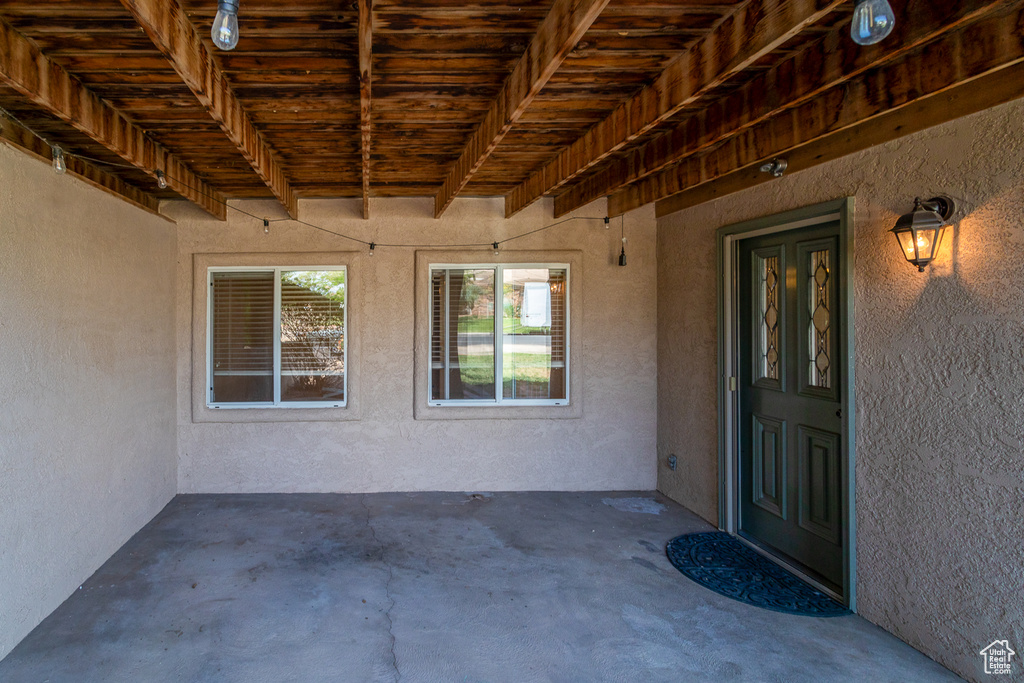 View of exterior entry with stucco siding and a patio
