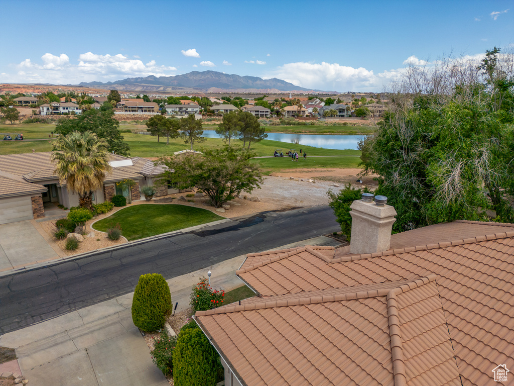 View of community with a water and mountain view, a residential view, a yard, and view of golf course