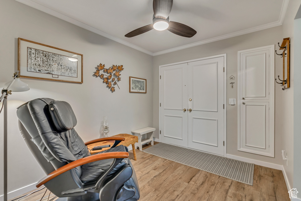 Entryway featuring light wood-type flooring, a ceiling fan, ornamental molding, and baseboards