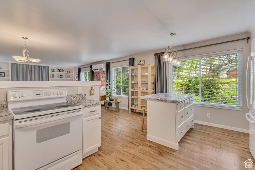 Kitchen with white appliances, a chandelier, white cabinetry, and pendant lighting