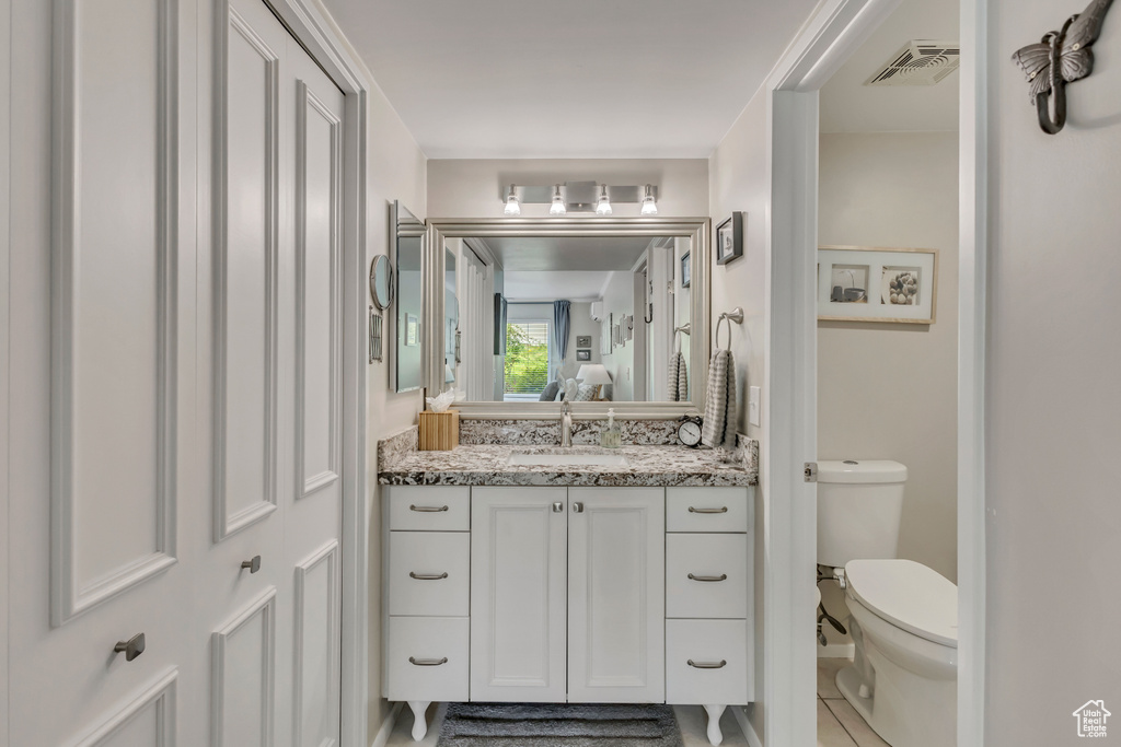 Bathroom with toilet, vanity, and tile patterned floors