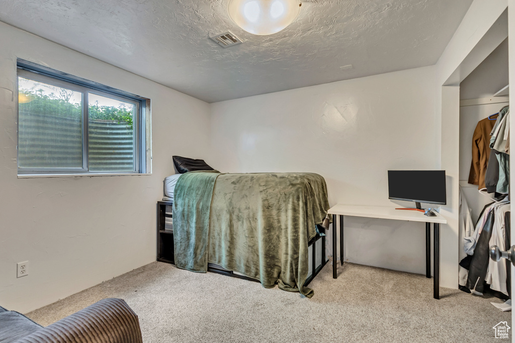 Carpeted bedroom featuring a textured ceiling