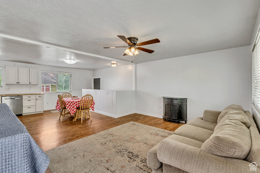 Living room with wood finished floors, ceiling fan, and baseboards
