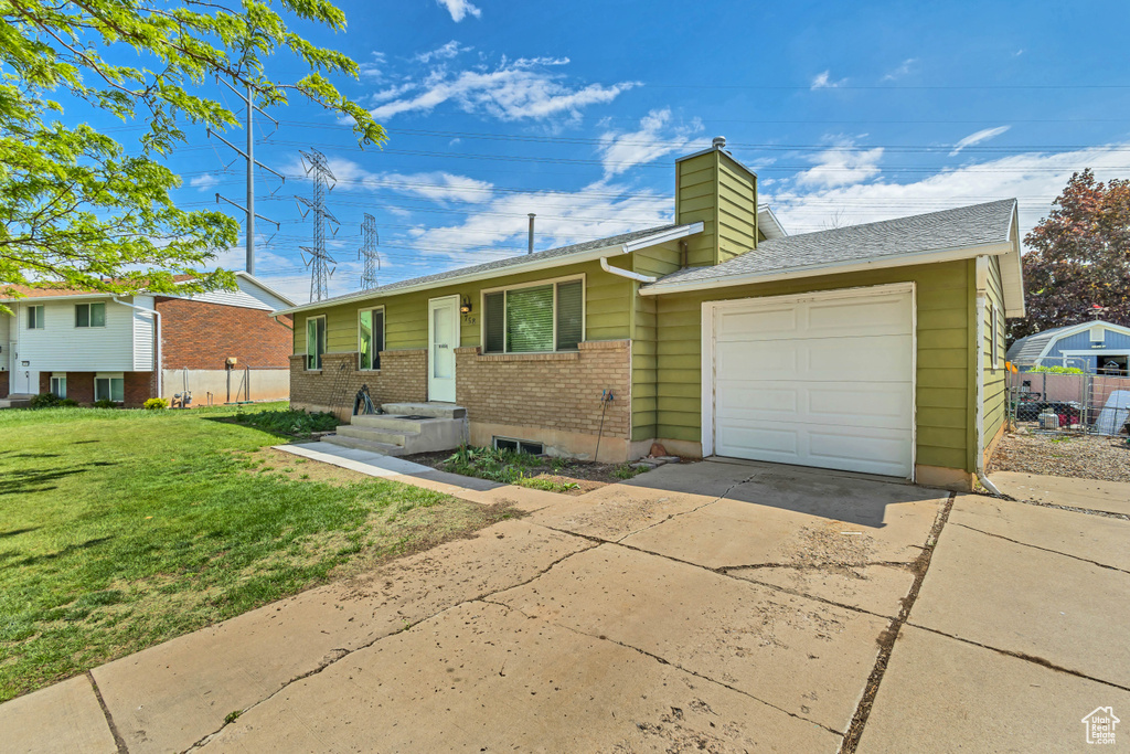 Ranch-style home featuring a garage, driveway, a chimney, brick siding, and a shingled roof