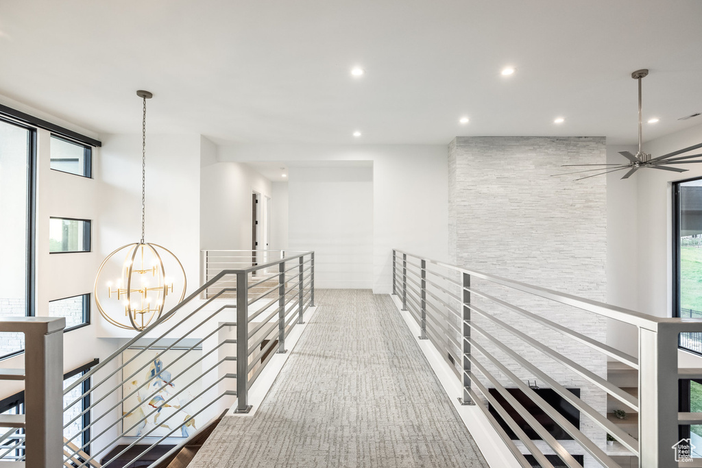 Hallway with an upstairs landing, a chandelier, recessed lighting, and carpet flooring