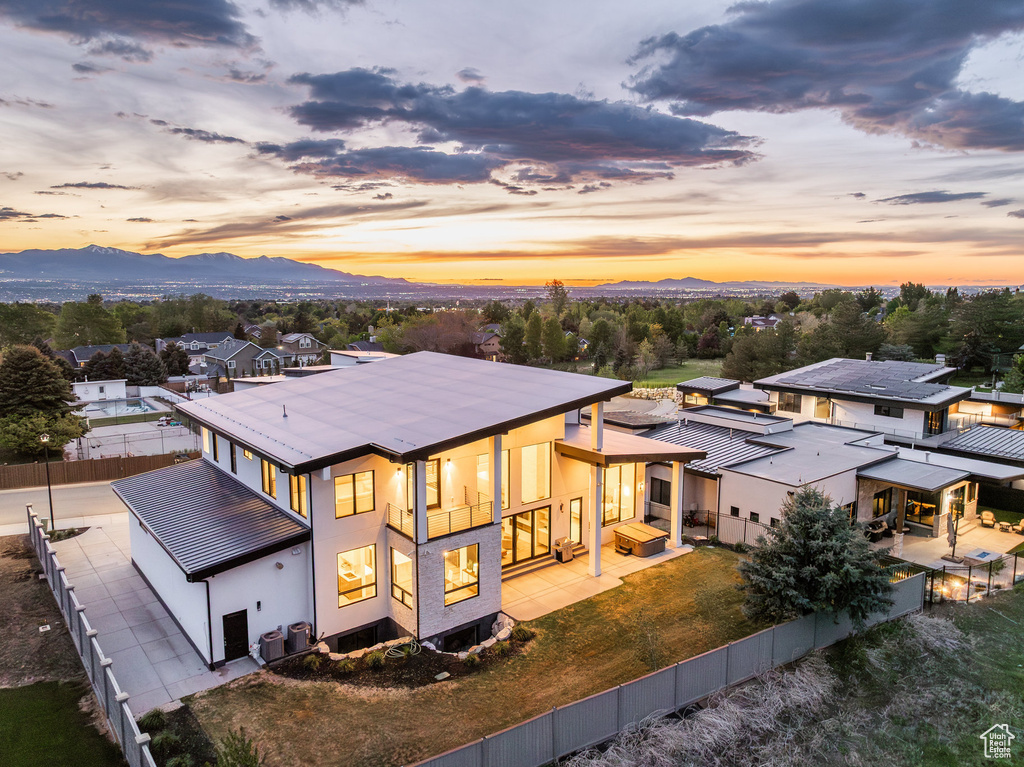 Rear view of property with a mountain view, a fenced backyard, stucco siding, and metal roof