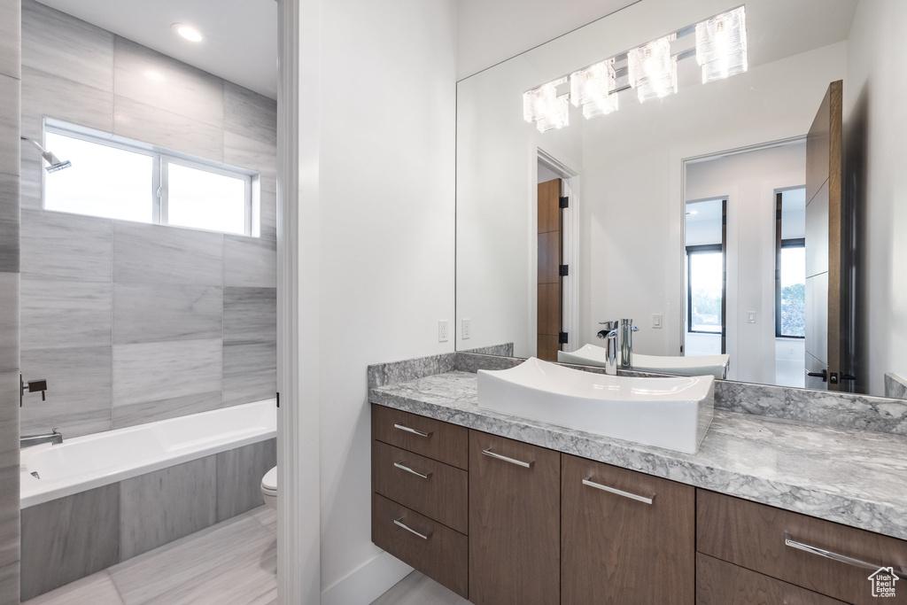 Bathroom with toilet, healthy amount of natural light, and vanity