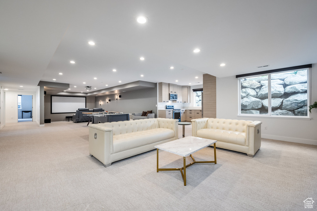 Living area featuring light colored carpet, recessed lighting, and baseboards