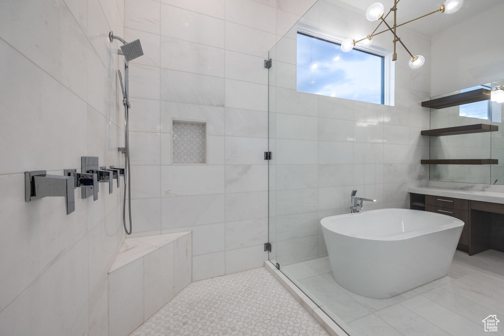 Full bathroom featuring tile walls, a stall shower, and a freestanding bath